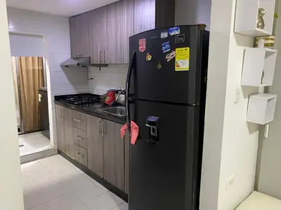 a black refrigerator in a kitchen with wooden cabinets at Posada encanto 2 cartagena in Cartagena de Indias