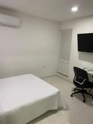 a bedroom with a bed and a desk and a computer at Posada encanto 2 cartagena in Cartagena de Indias