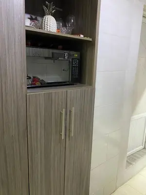 a brown cabinet with a microwave in it at Posada encanto 2 cartagena in Cartagena de Indias