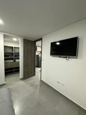 a living room with a flat screen tv on a wall at Beautiful, apartment near CC Único, Estadio R Martinez in Barranquilla