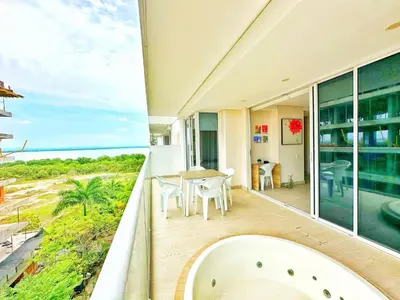 a balcony with a table and chairs and a view of the ocean at Cartagena Cielo Mar Apartment Steps from the Beach in Cartagena de Indias