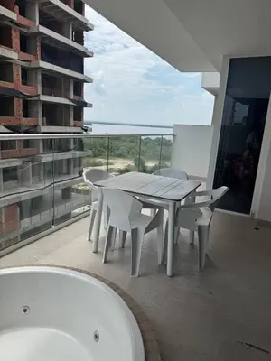 a white table and chairs on a balcony with a bath tub at Cartagena Cielo Mar Apartment Steps from the Beach in Cartagena de Indias