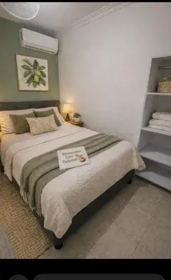 a bedroom with a large bed with a sign on it at Casa Guayabal hostal& cocina in Cartagena de Indias