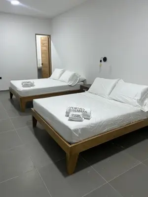two beds in a room with white walls at Hotel Porton De La Sabana in San Onofre