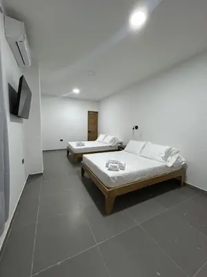 a room with two beds and a flat screen tv at Hotel Porton De La Sabana in San Onofre