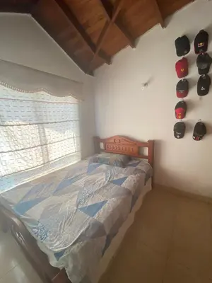 a bedroom with a bed and a window with hats on the wall at Habitación doble en casa de conjunto cerrado in Barranquilla