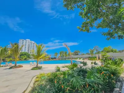 a resort with a swimming pool and palm trees at Loft Premium con Vista al Mar in Santa Marta