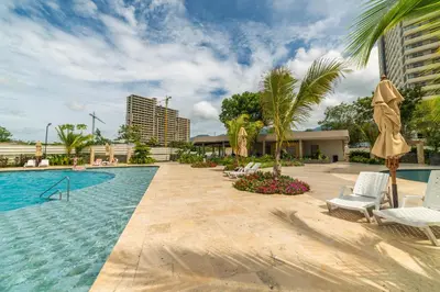 a pool with chairs and umbrellas next to a resort at Loft Premium con Vista al Mar in Santa Marta