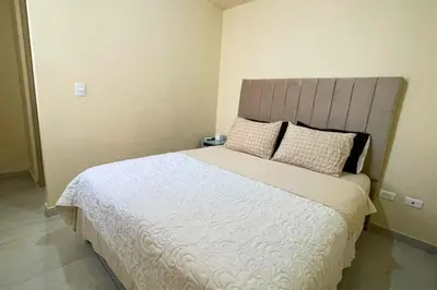 a bedroom with a large bed with white sheets and pillows at Apartamento cómodo, ubicación excelente in Barranquilla