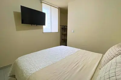 a bedroom with a bed with a flat screen tv on the wall at Apartamento cómodo, ubicación excelente in Barranquilla
