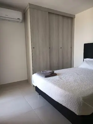a bedroom with a white bed and a wooden wall at loft relax con vista al mar in Cartagena de Indias