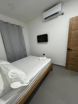 a bedroom with a bed and a tv on the wall at Hotel Portón de La Sabana in San Onofre