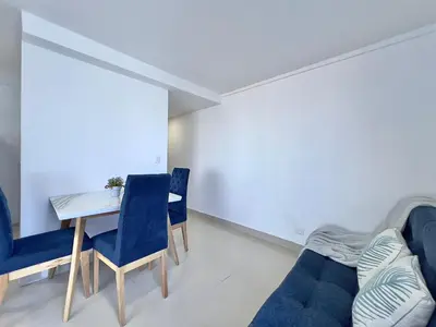 a living room with a table and blue chairs at Apartamento con vista al mar - Riviera Mulata Beach in Cartagena de Indias