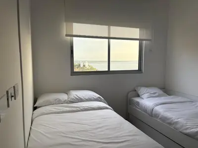 two beds in a room with a window at Horizonte Infinito - Calidez frente al mar Santa Marta in Santa Marta