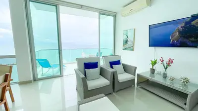 a living room with chairs and a table and windows at Magico Apartamento Frente al Mar 3 Habitaciones BM81 in Coveñas