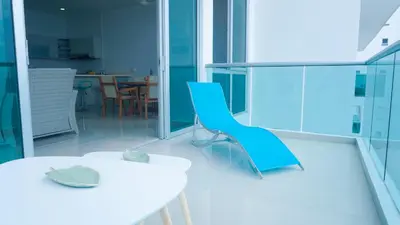 a room with a white table and a blue chair at Magico Apartamento Frente al Mar 3 Habitaciones BM81 in Coveñas