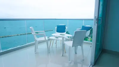 a balcony with chairs and a table and a view of the ocean at Magico Apartamento Frente al Mar 3 Habitaciones BM81 in Coveñas