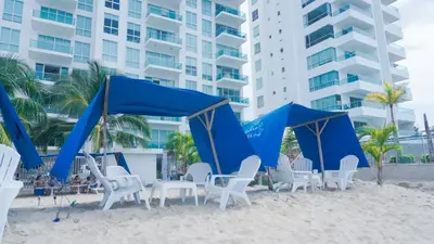 a group of chairs and blue tents on the beach at Magico Apartamento Frente al Mar 3 Habitaciones BM81 in Coveñas