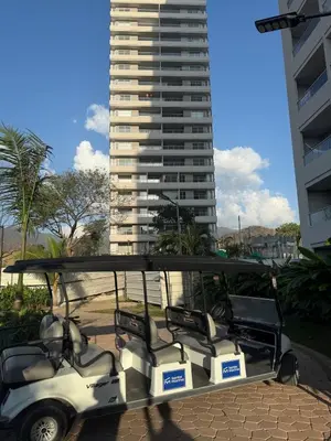 a golf cart parked in front of a tall building at New apartment on the 18th floor in Santa Marta with ocean views in Simón Bolivar