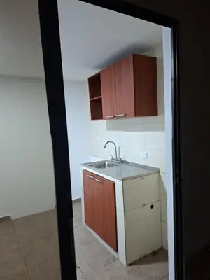 a kitchen with a sink and wooden cabinets at Apartamento amoblado in Barranquilla