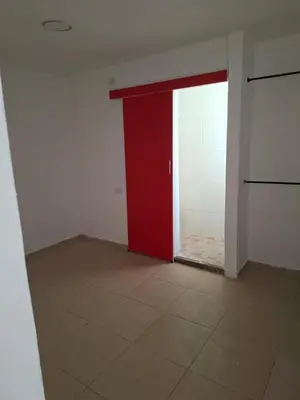 an empty room with a red door and a tile floor at Apartamento amoblado in Barranquilla