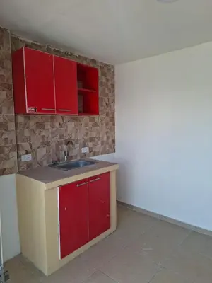 a kitchen with red cabinets and a sink at Apartamento amoblado in Barranquilla