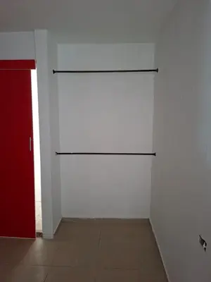 a room with a white wall and a red door at Apartamento amoblado in Barranquilla