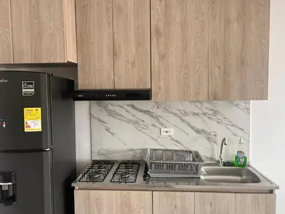 a kitchen with a sink and a stove and a refrigerator at Beach 1203 Lotus Cartagena in Cartagena de Indias