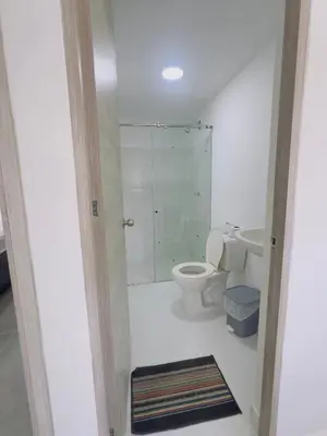 a white bathroom with a toilet and a shower at Beach 1203 Lotus Cartagena in Cartagena de Indias