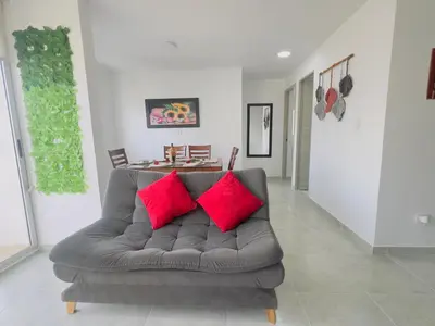a couch with two red pillows in a living room at Beach 1203 Lotus Cartagena in Cartagena de Indias