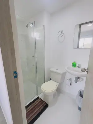 a white bathroom with a toilet and a shower at Beach 1203 Lotus Cartagena in Cartagena de Indias