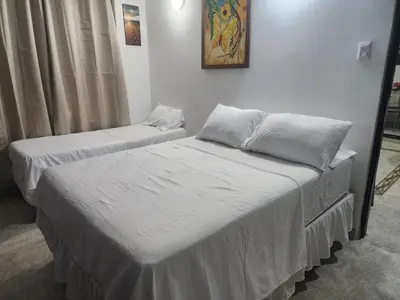 two beds with white sheets in a room at Capri apartamento in Guayepo