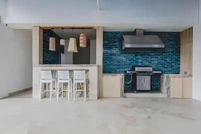 a kitchen with two stools in a room with blue bricks at Ocean View Loft Altamar in Cartagena de Indias