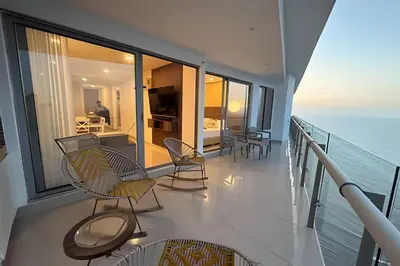 a balcony with chairs and a room with the ocean at Ocean View Loft Altamar in Cartagena de Indias