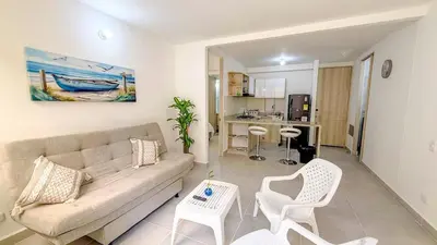 a living room with a couch and chairs and a kitchen at Apartamento moderno cerca del mar - Cartagena in Cartagena de Indias