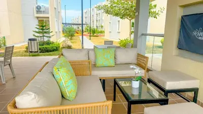 a patio with two couches and a glass table at Apartamento moderno cerca del mar - Cartagena in Cartagena de Indias