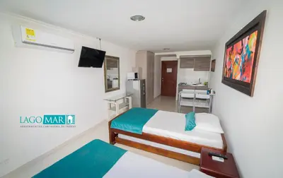 a small room with two beds and a kitchen at Marea Laguito Apartamentos Cartagena in Cartagena de Indias