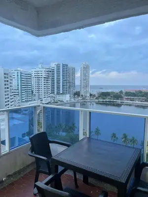 a balcony with a table and chairs and a view of the city at Marea Laguito Apartamentos Cartagena in Cartagena de Indias