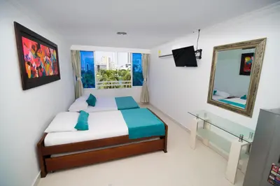 a small bedroom with a bed and a mirror at Marea Laguito Apartamentos Cartagena in Cartagena de Indias