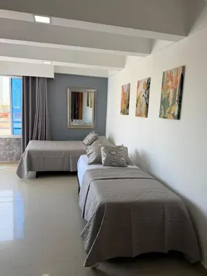 a bedroom with two beds and a mirror on the wall at Lujoso Apartamento en Cartagena in Cartagena de Indias
