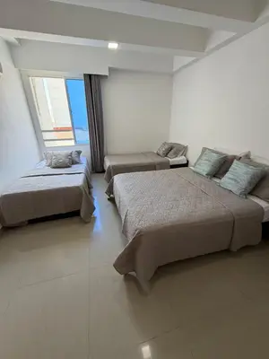 two beds in a room with two windows at Lujoso Apartamento en Cartagena in Cartagena de Indias