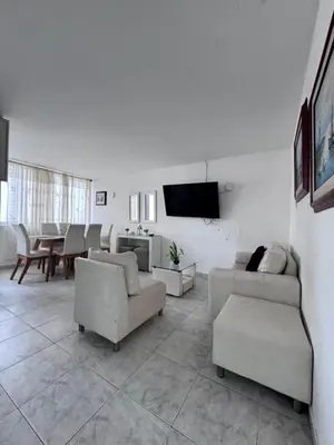a living room with couches and a flat screen tv at Delfines De Bocagrande in Cartagena de Indias