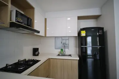 a kitchen with a black refrigerator and a sink at Praseo in Serena del Mar