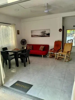a living room with a red couch and a table at Sandymar in San Bernardo del Viento