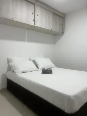 a bedroom with a bed with white sheets and cabinets at Spacious Flat with stunning Views Great Location in Cartagena de Indias