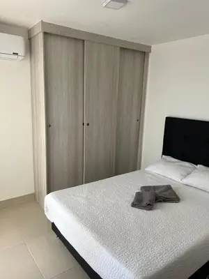 a bedroom with a bed with a wooden cabinet at Spacious Flat with stunning Views Great Location in Cartagena de Indias