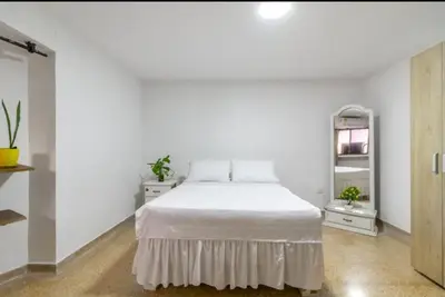 a white bedroom with a bed and two night stands at Refugio Cartagena Kawica Bocagrande in Cartagena de Indias