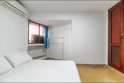 a white room with a bed and a window at Refugio Cartagena Kawica Bocagrande in Cartagena de Indias