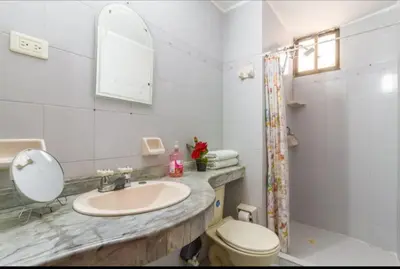 a bathroom with a sink and a toilet and a mirror at Refugio Cartagena Kawica Bocagrande in Cartagena de Indias