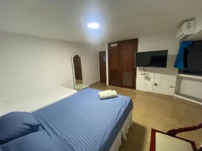 a hotel room with a bed and a tv at Refugio Cartagena Kawica Bocagrande in Cartagena de Indias